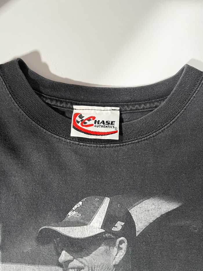 Black godaddy vintage t-shirt featuring Mark Martin, a very successful former racing driver. Considered one of the greatest drivers in NASCAR history. Positioned on a neutral white background.