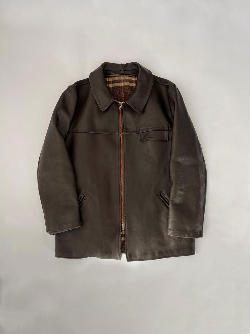 French brown leather jacket/coat, produced approximately in the 1960s by the French brand GVF, characterized by a long and robust design, completed by an Eclair zip.