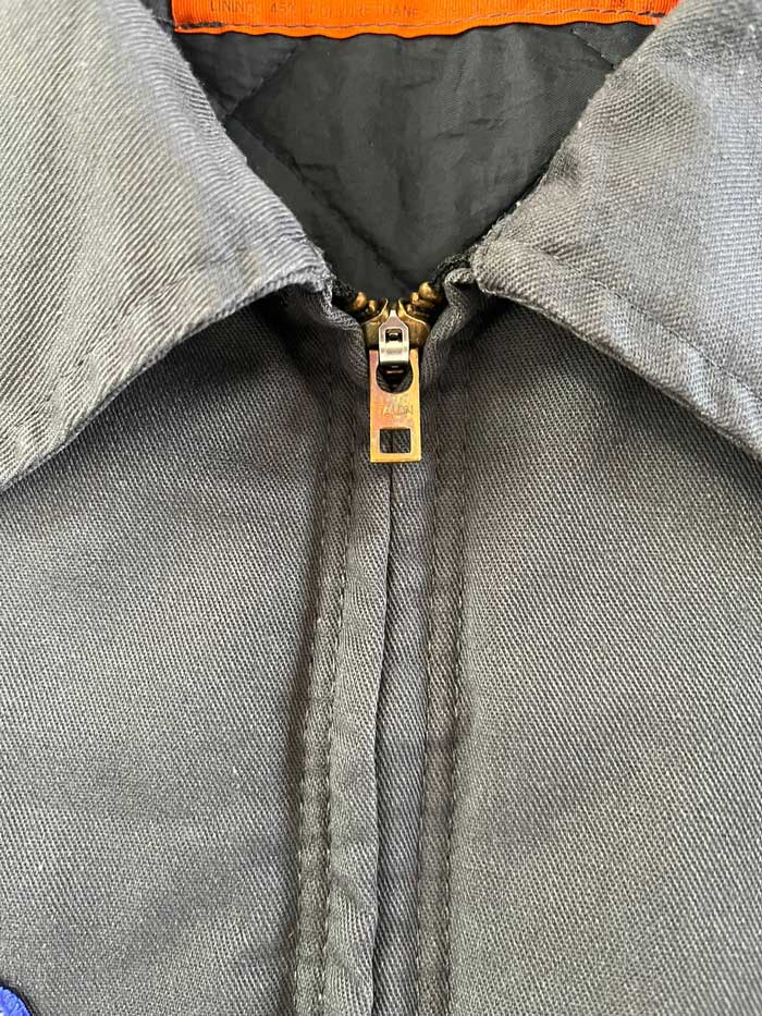 Vintage work jacket produced in the 1990s by Red Kap. Quality fabric and perfectly maintained over time. Talon zip and double patch applied on the front. Positioned on a neutral white background.