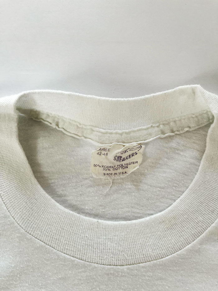 Single stitch tee white produced in the United States in the 80s by Sneakers. Print on the front depicting a duck with written "this is Duckpin Country". Rare.