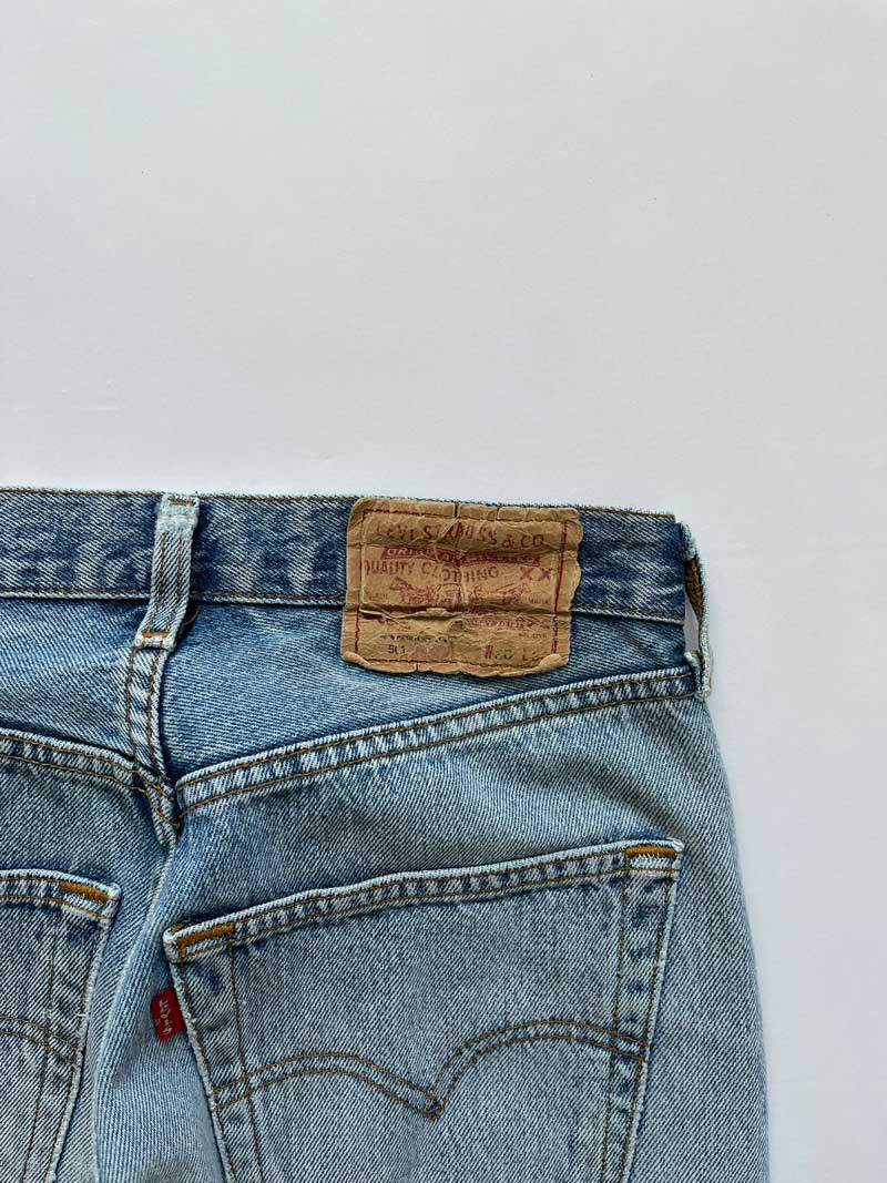 Vintage Levi's 501 jeans placed on a neutral white background. Jeans blue color.