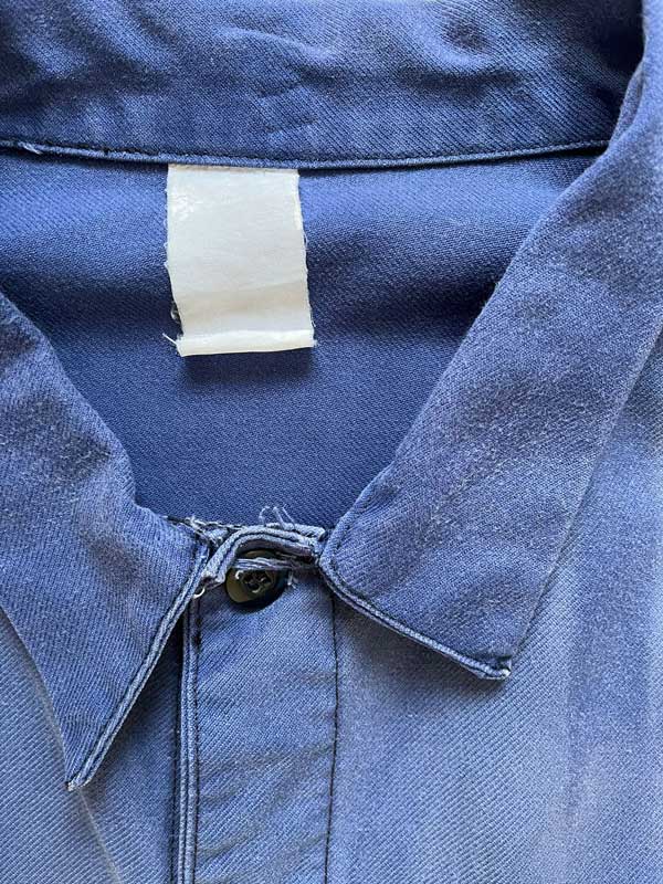 French work jacket from the 70s of Port De Bordeaux. Made from quality, durable cotton. The different shades of blue give a unique character to this jacket. Positioned on a neutral white background.