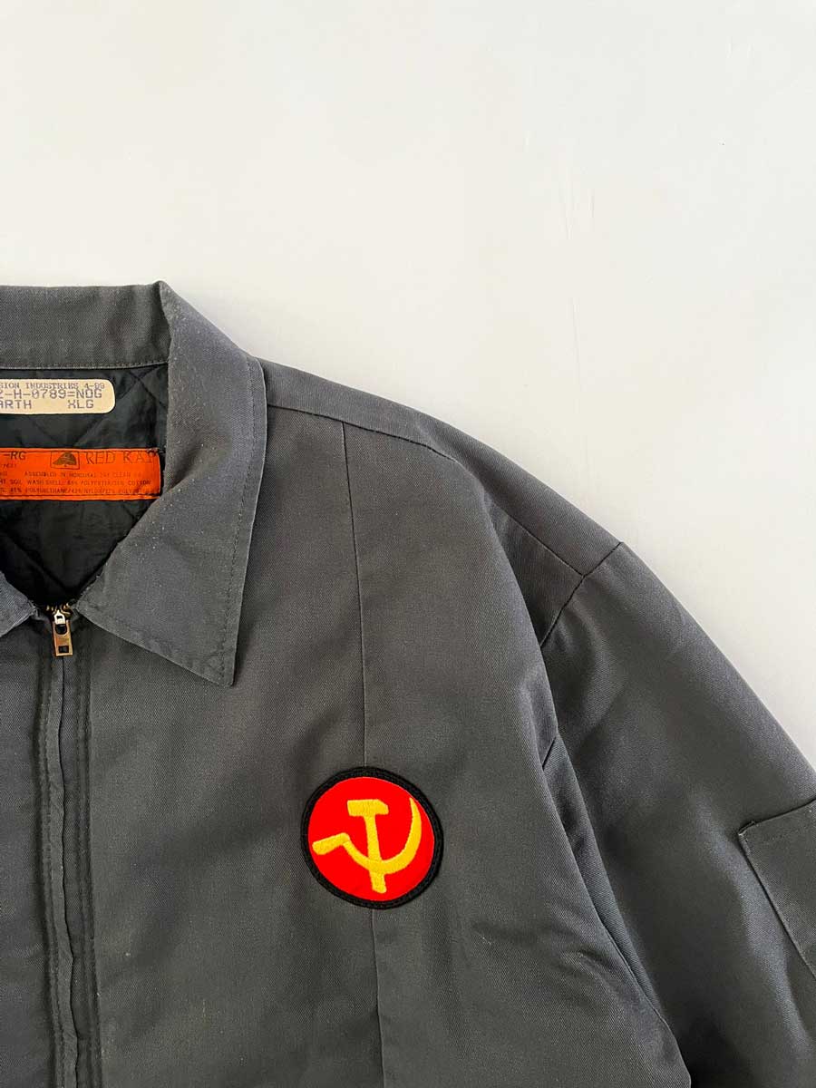 Vintage work jacket produced in the 1990s by Red Kap. Quality fabric and perfectly maintained over time. Talon zip and double patch applied on the front. Positioned on a neutral white background.