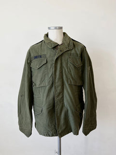 Vintage US Army M65 Field Jacket from the 1980s. Patches applied on the front and complete with all original labels. Size between medium and large.