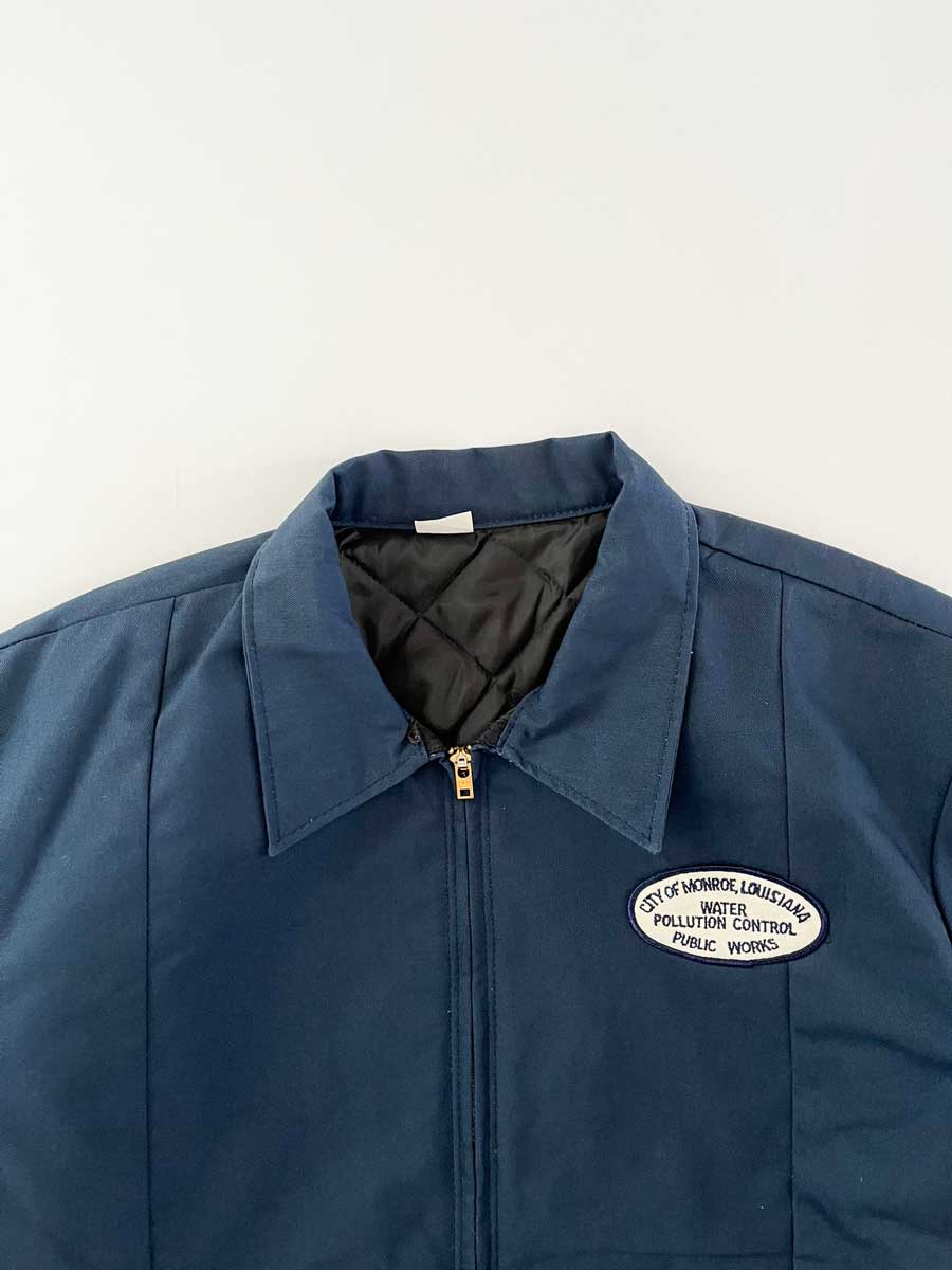 Vintage work jacket blue produced in the 1990s by Red Kap. Quality fabric and perfectly maintained over time. Talon zip and patch applied on the front. Positioned on a neutral white background.