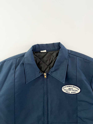 Vintage work jacket blue produced in the 1990s by Red Kap. Quality fabric and perfectly maintained over time. Talon zip and patch applied on the front. Positioned on a neutral white background.