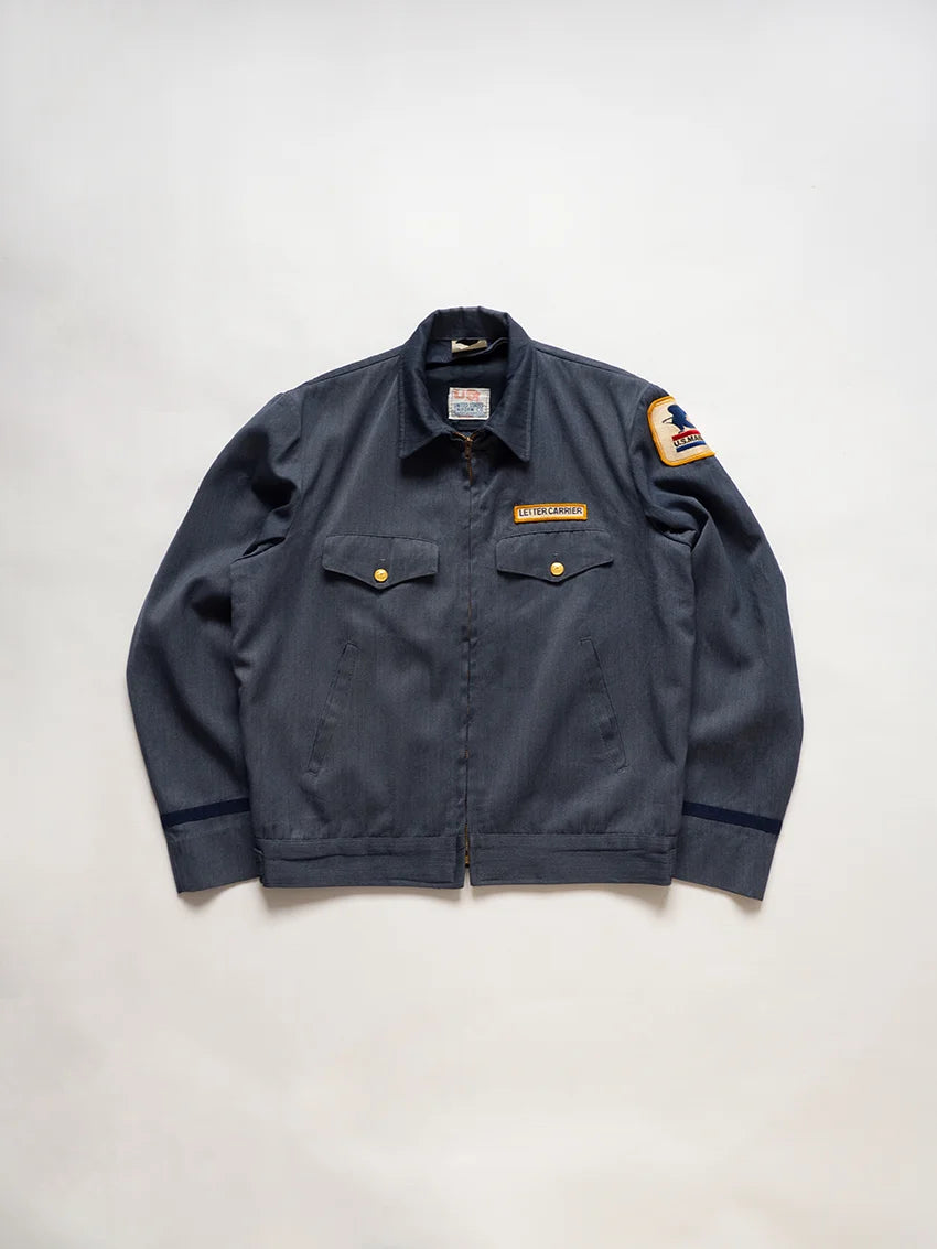 1970s Vintage USPS Letter Carrier Jacket. The color is a blue-gray. Made in USA, produced by United States Uniform Co. Boxy fit. United States Postal Service.