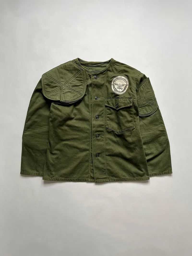 Giacca da tiro dell'USMC (US Marine Corps) prodotta indicativamente negli anni 70, molto probabilmente durante la guerra del Vietnam. Costruzione in 100% cotone, con gomiti e spalla rinforzati.
Toppa "Director of Civilian Marksmanship" - possibile che fosse utilizzata nell'ambito di addestramenti o competizioni del programma DCM, che inizialmente era gestito principalmente dall'Esercito degli Stati Uniti.