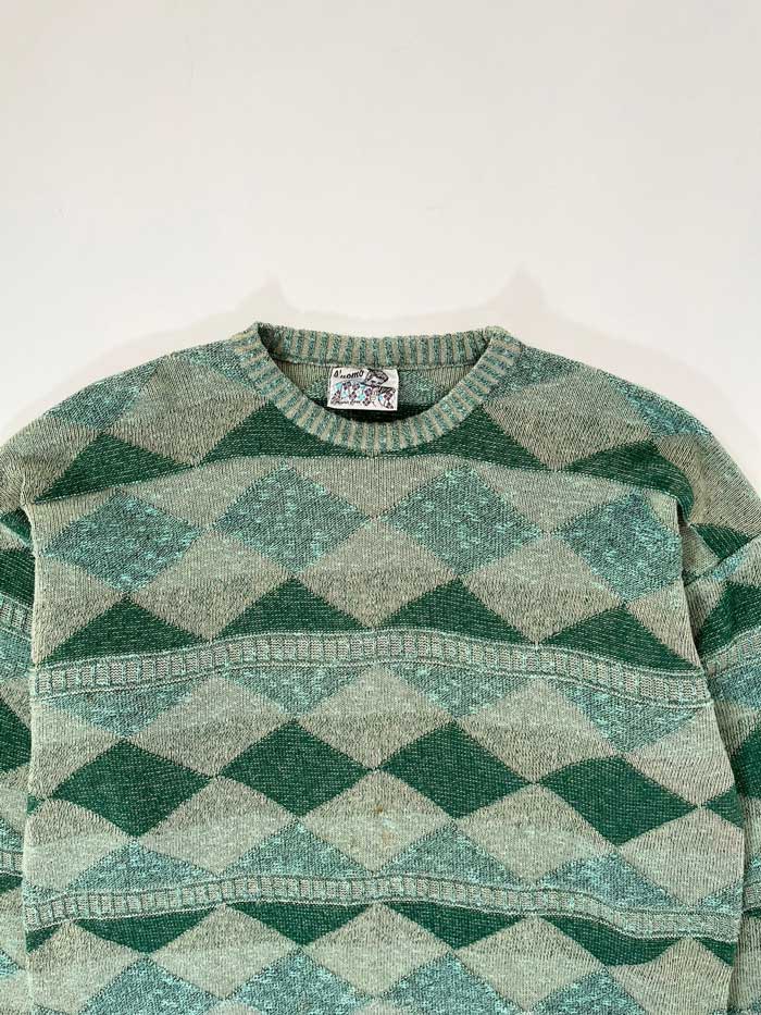 Green vintage sweater from the 90s. Wool fabric. Placed on a neutral white background.