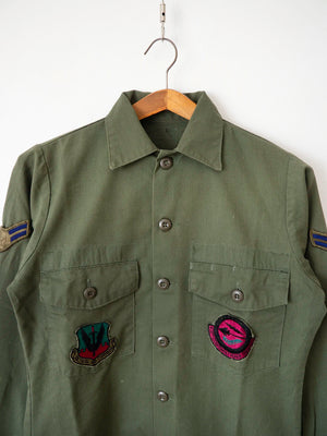 Close-up of the two US Air Force squadron patches on the chest pockets of the OG-507 shirt.