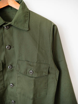 Detail of the button-flap pocket and collar on the OG-507 utility shirt, size L.