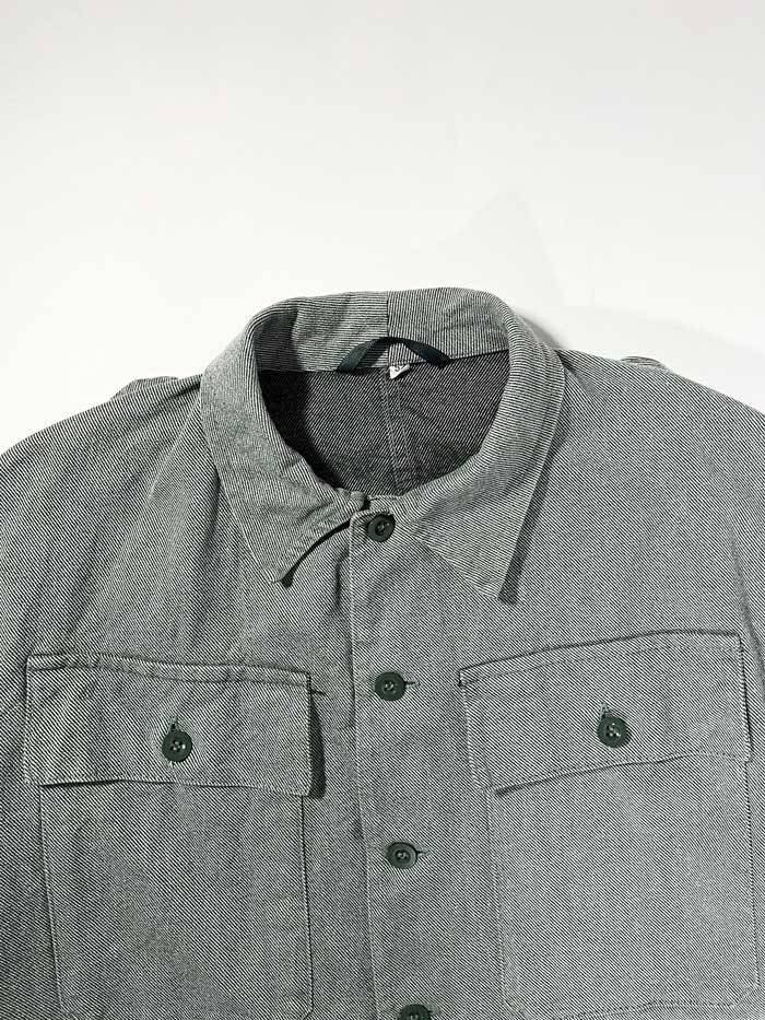 Swiss Army Denim Work Jacket produced from the 1950s to the 1990s by the Swiss Army. Color ranging from gray to greenish, made of thick, quality denim fabric. It has a workwear look but at the same time elegant, so it can be used in any situation. Positioned on a neutral white background.