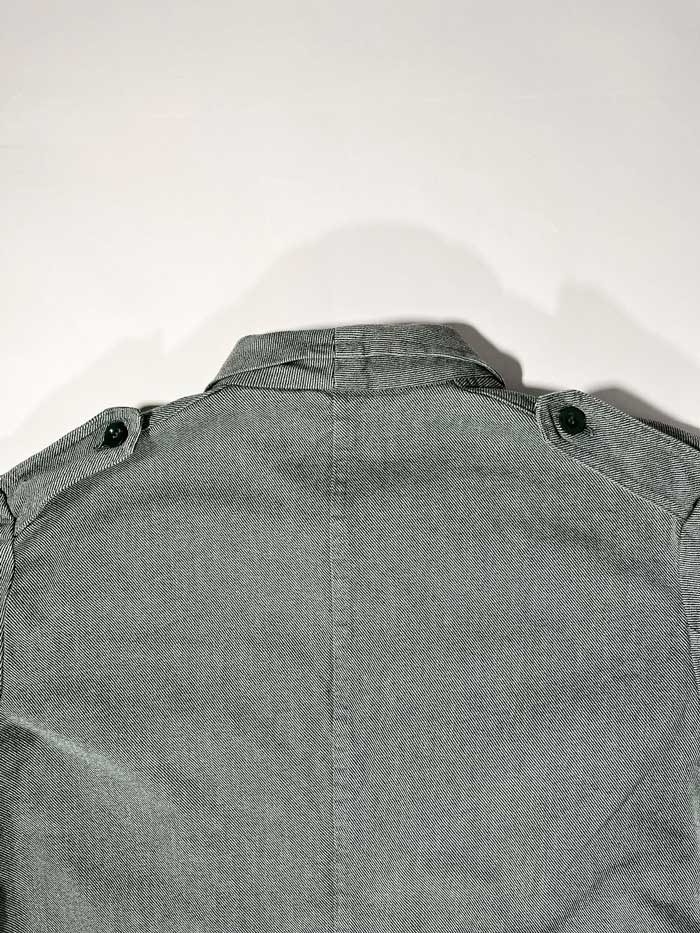 Swiss Army Denim Work Jacket produced from the 1950s to the 1990s by the Swiss Army. Color ranging from gray to greenish, made of thick, quality denim fabric. It has a workwear look but at the same time elegant, so it can be used in any situation. Positioned on a neutral white background.