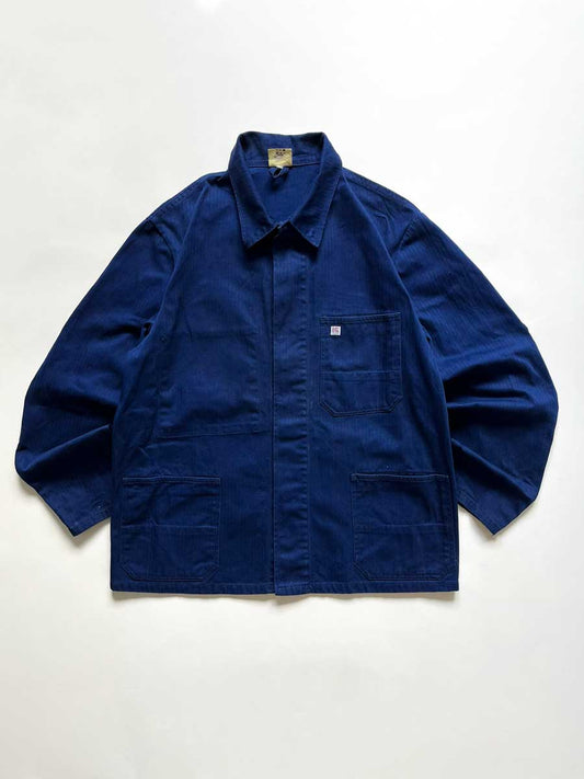 Vintage blue work jacket in hbt cotton. Quality fabric and a faded blue color given by the passage of time. Placed on a neutral white background.
