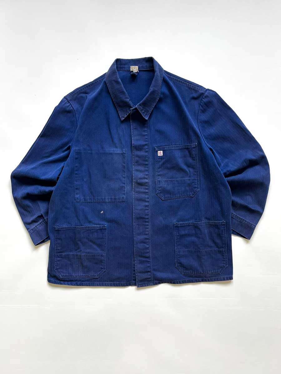 Vintage blue work jacket in hbt cotton. Quality fabric and a faded blue color given by the passage of time. Placed on a neutral white background.