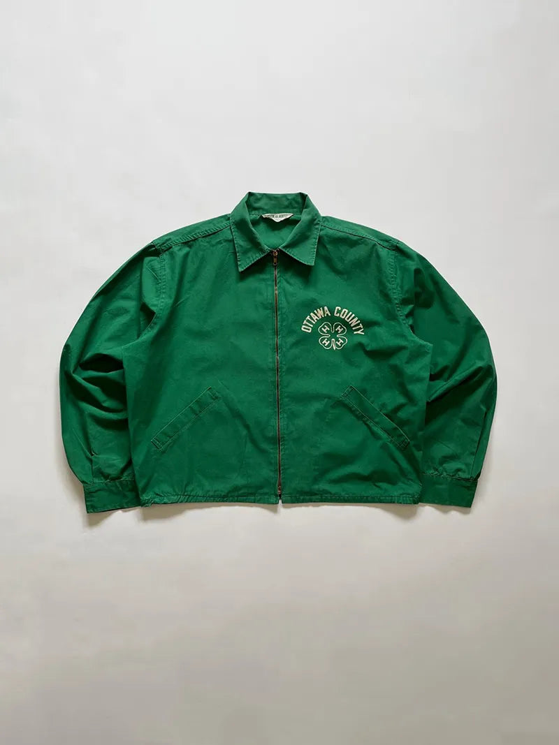 50's 4-H Work Jacket. Made in the USA from a cotton blend, it features a beautiful green with a white four-leaf clover print on the front and back. Zip Crown.