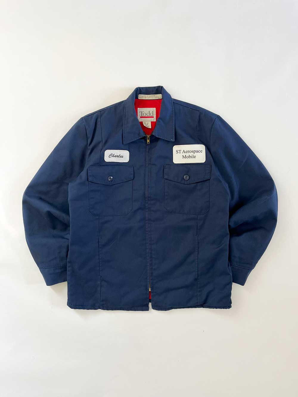 Vintage work jacket produced in the 1980s by Tod Quality fabric and perfectly maintained over time. Patch applied on the front, "Charles" e "ST Engineering". Positioned on a neutral white background.