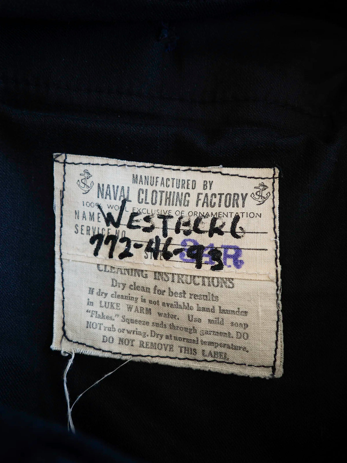 Etichetta originale Naval Clothing Factory, 100% lana, con nome e numero di servizio