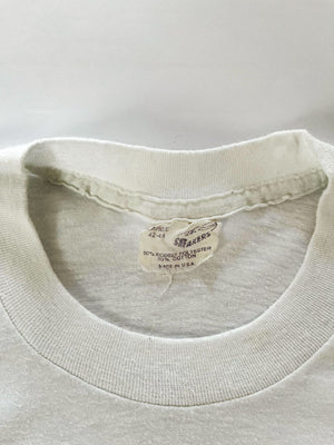 Single stitch tee white produced in the United States in the 80s by Sneakers. Print on the front depicting a duck with written "this is Duckpin Country". Rare.