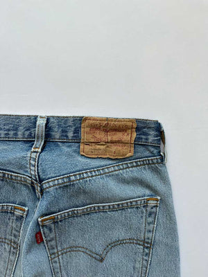 Vintage Levi's 501 jeans placed on a neutral white background. Jeans blue color.