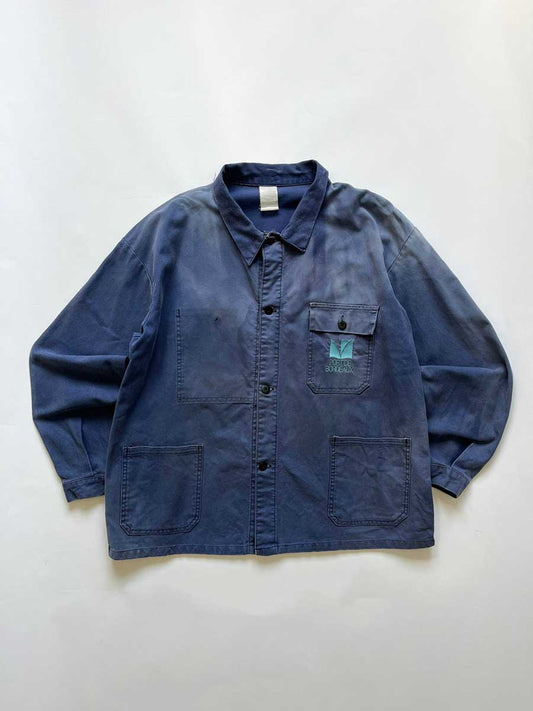 French work jacket from the 70s of Port De Bordeaux. Made from quality, durable cotton. The different shades of blue give a unique character to this jacket. Positioned on a neutral white background.