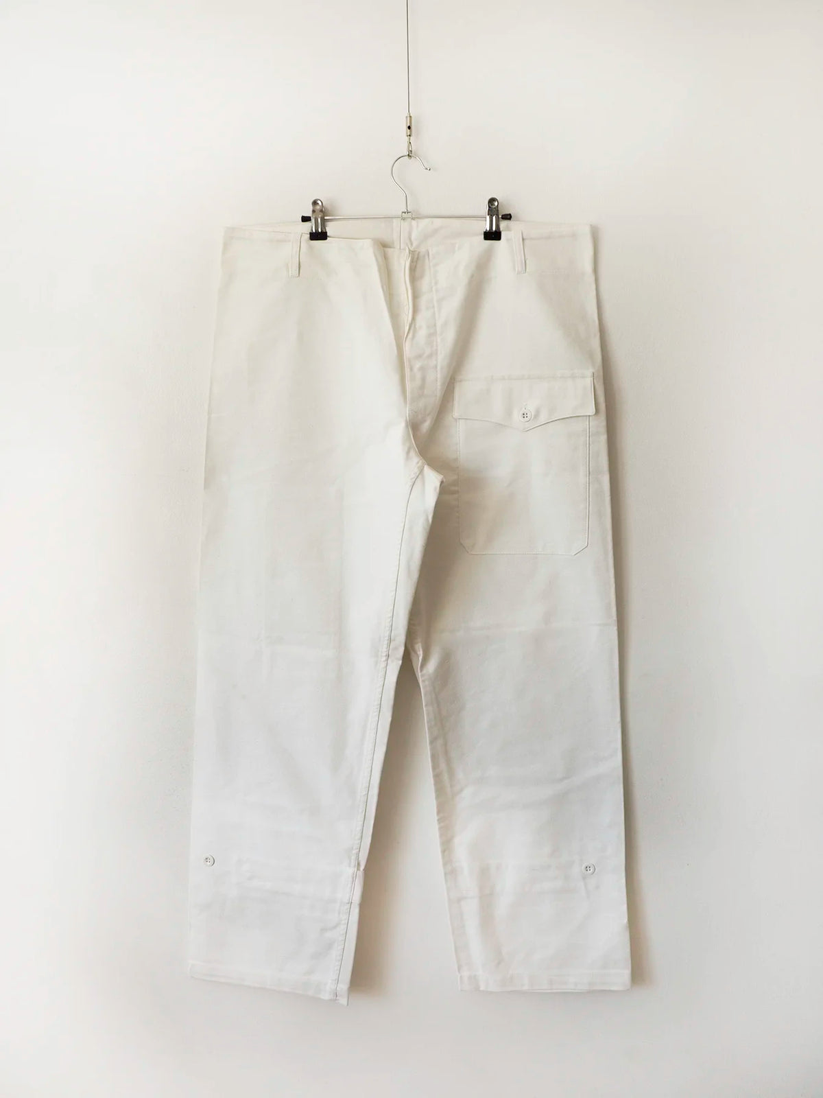 Pantaloni bianchi Marina Militare Italiana su gruccia, vista frontale