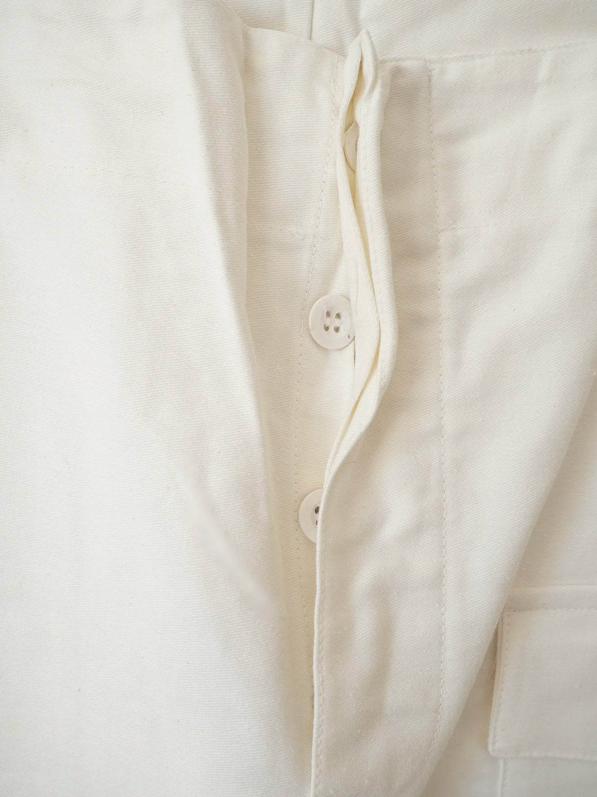 Dettaglio della chiusura con bottoni dei pantaloni bianchi Marina Italiana