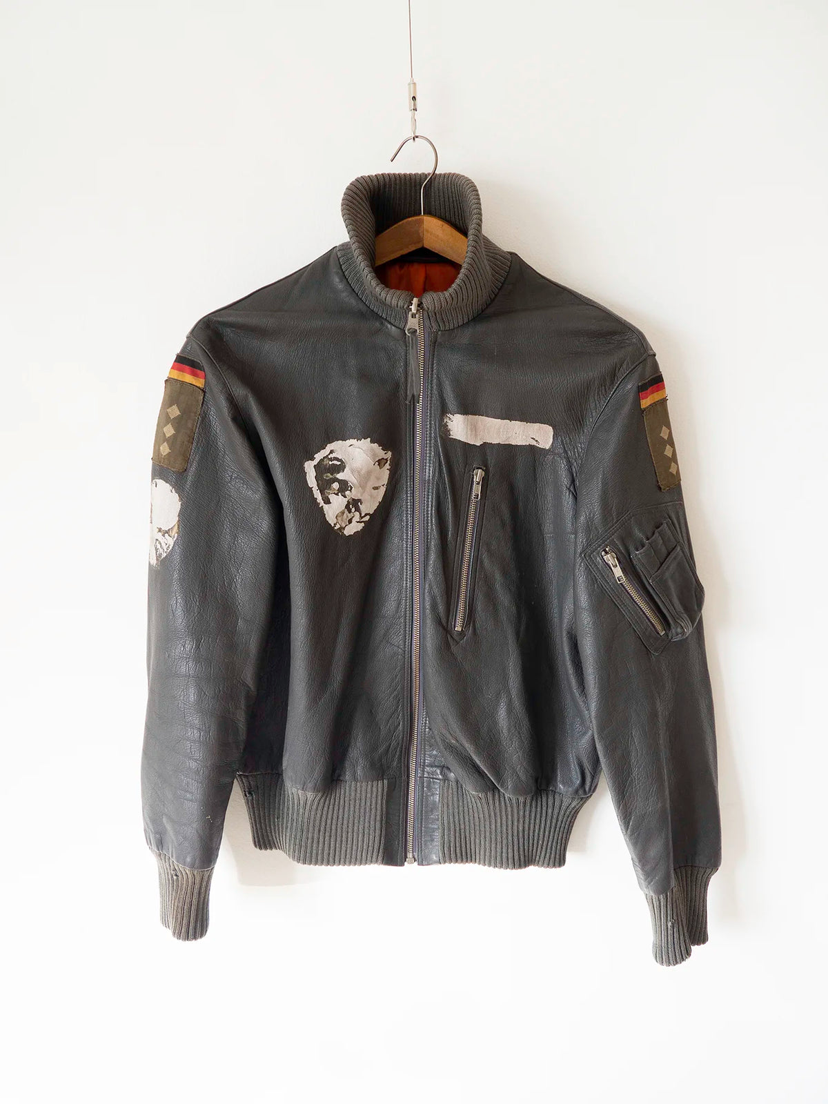 Giacca in pelle Luftwaffe tedesca vintage nera, vista frontale su gruccia