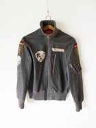 Giacca in pelle Luftwaffe tedesca vintage nera, vista frontale su gruccia