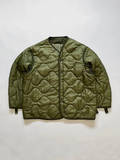 Vintage US Army M65 Liner Jacket size Large. The construction includes a front button closure and an open underarm design for greater breathability and comfort.