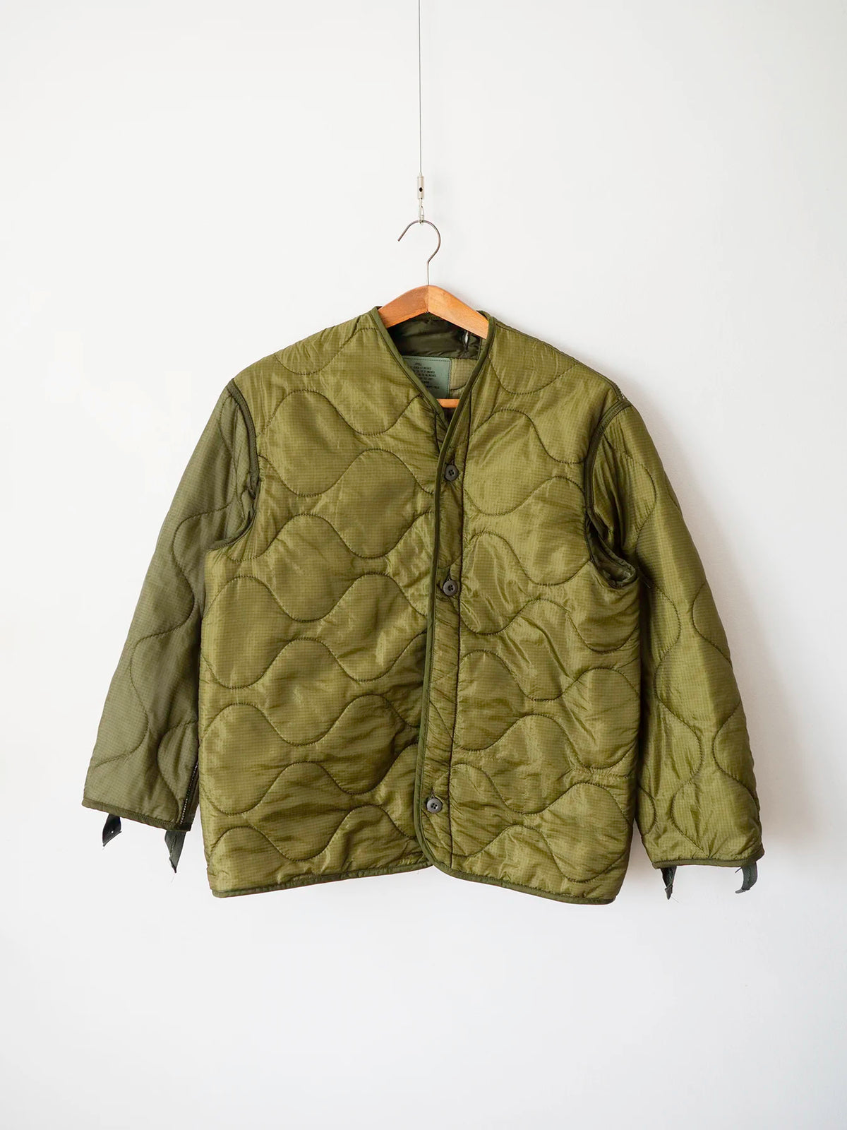 Liner M65 US Army anni 80 verde oliva, vista frontale su gruccia