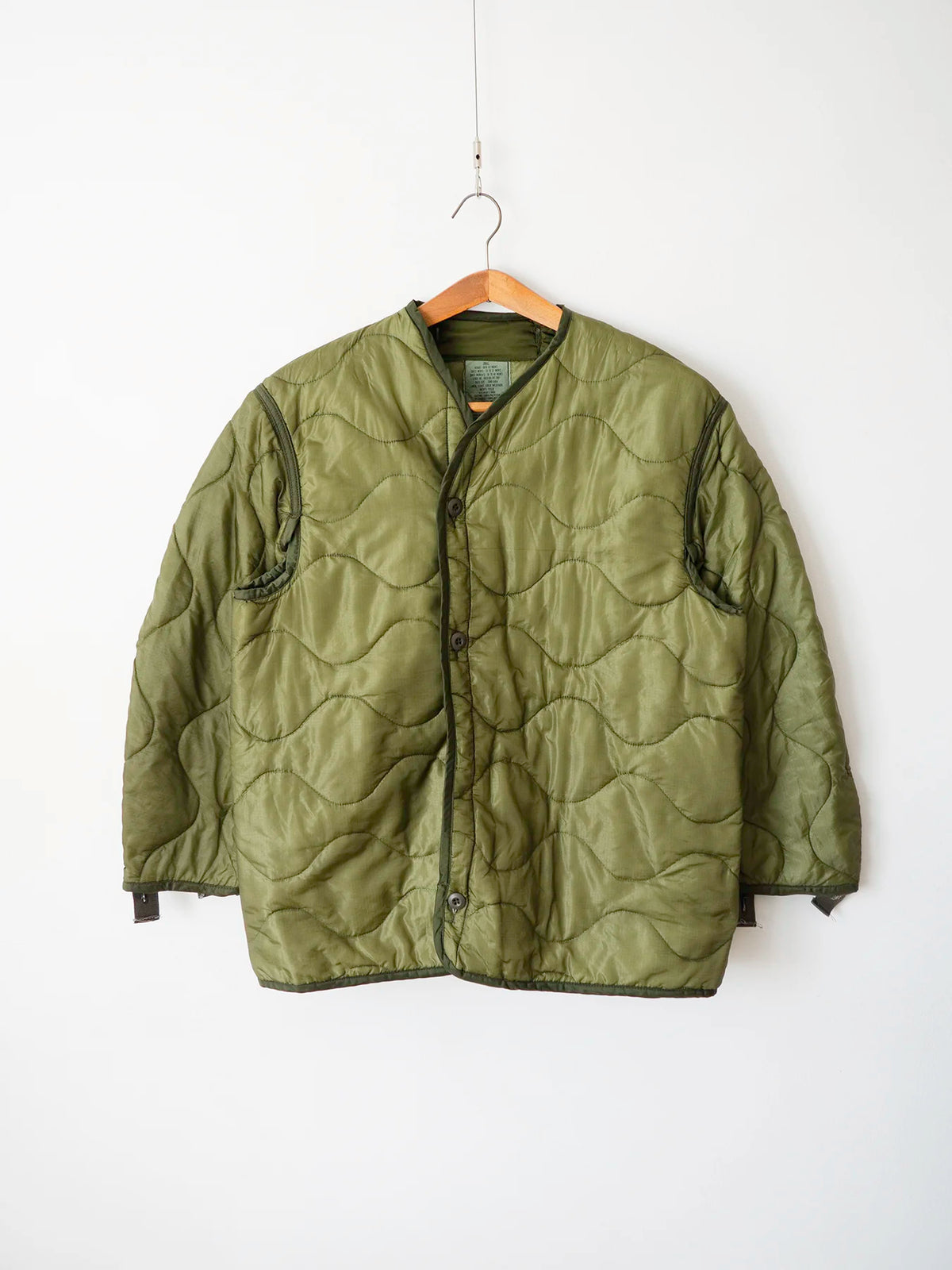 Liner M65 US Army anni 80 verde oliva, vista frontale su gruccia