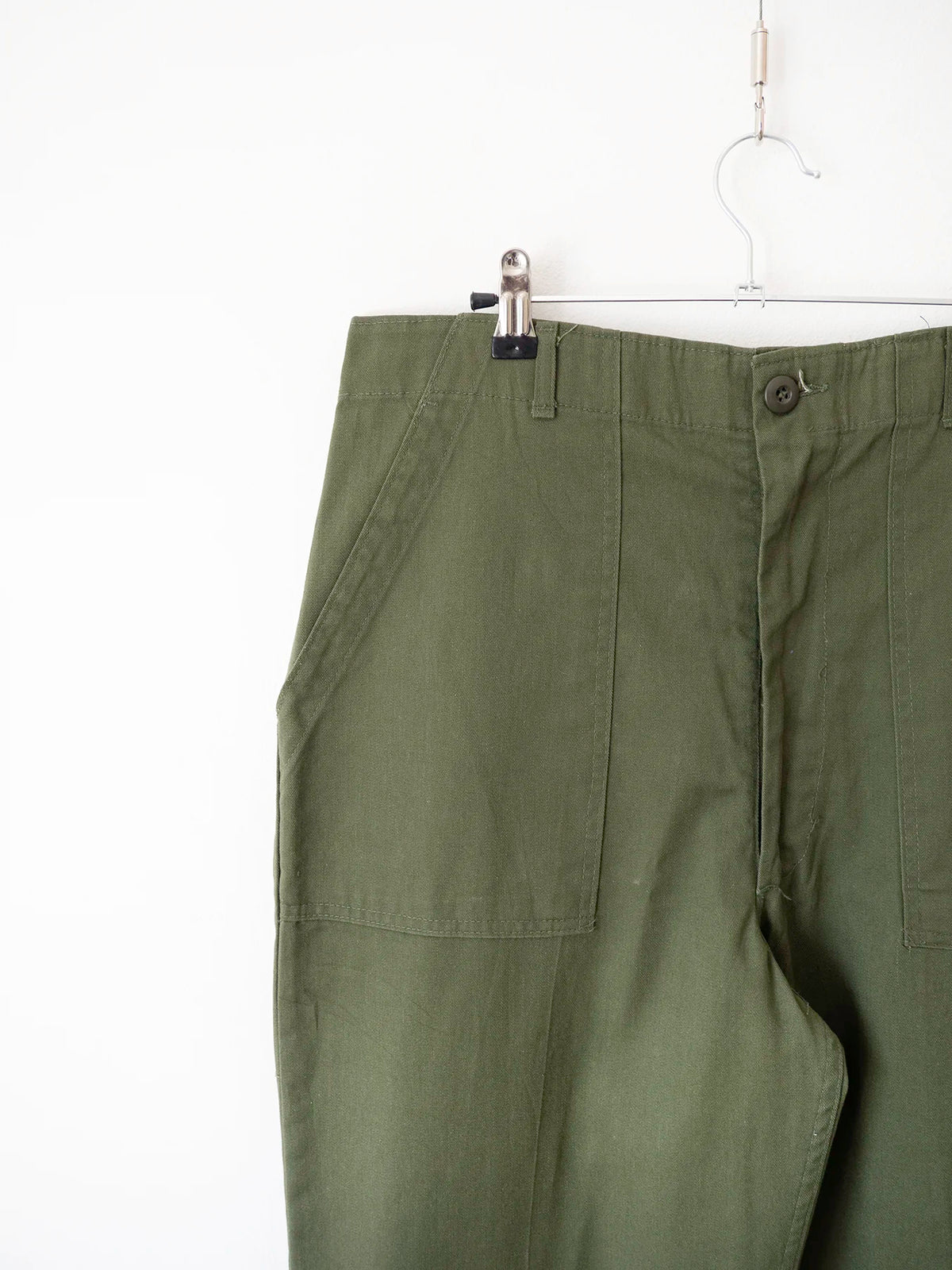 Primo piano della tasca anteriore sinistra a toppa e dei passanti in vita dei pantaloni OG 507