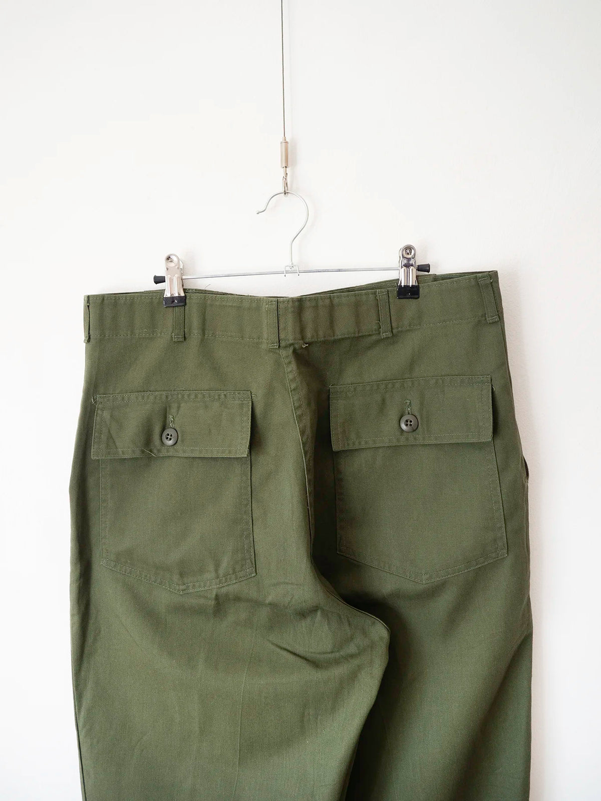 Dettaglio delle due tasche posteriori con patta e bottone dei pantaloni OG 507
