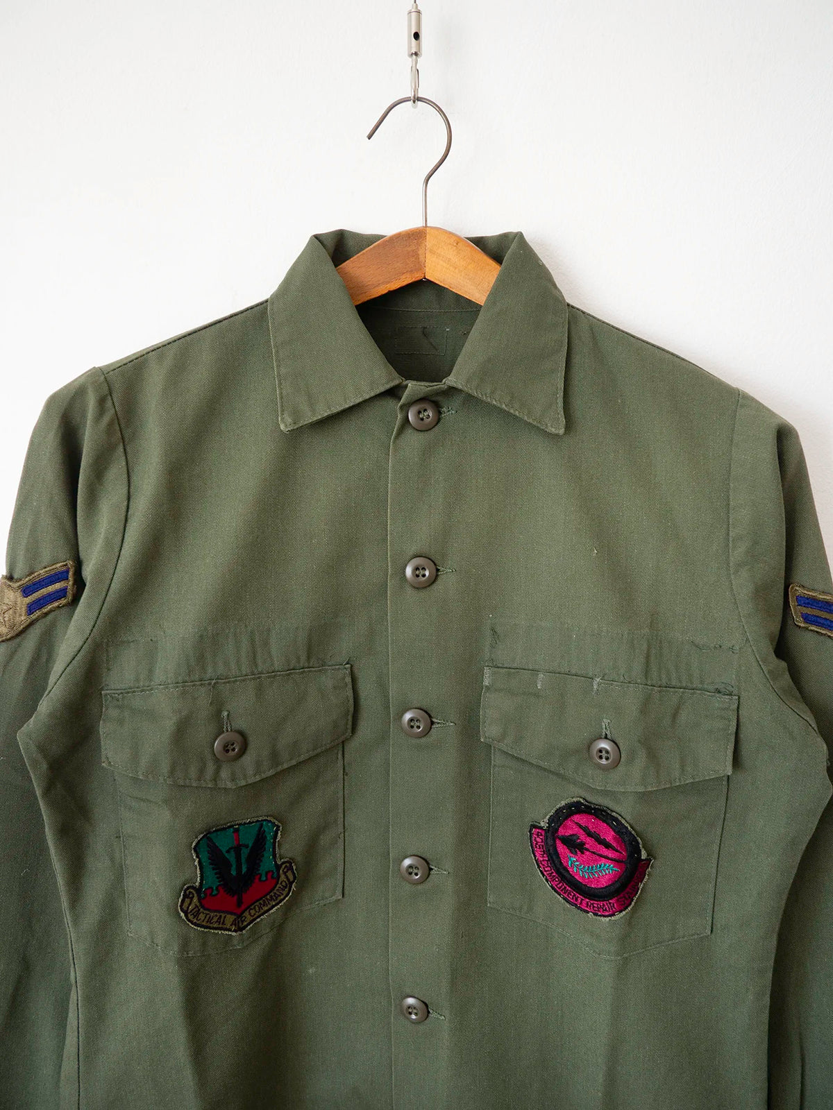 Close-up of the two US Air Force squadron patches on the chest pockets of the OG-507 shirt.