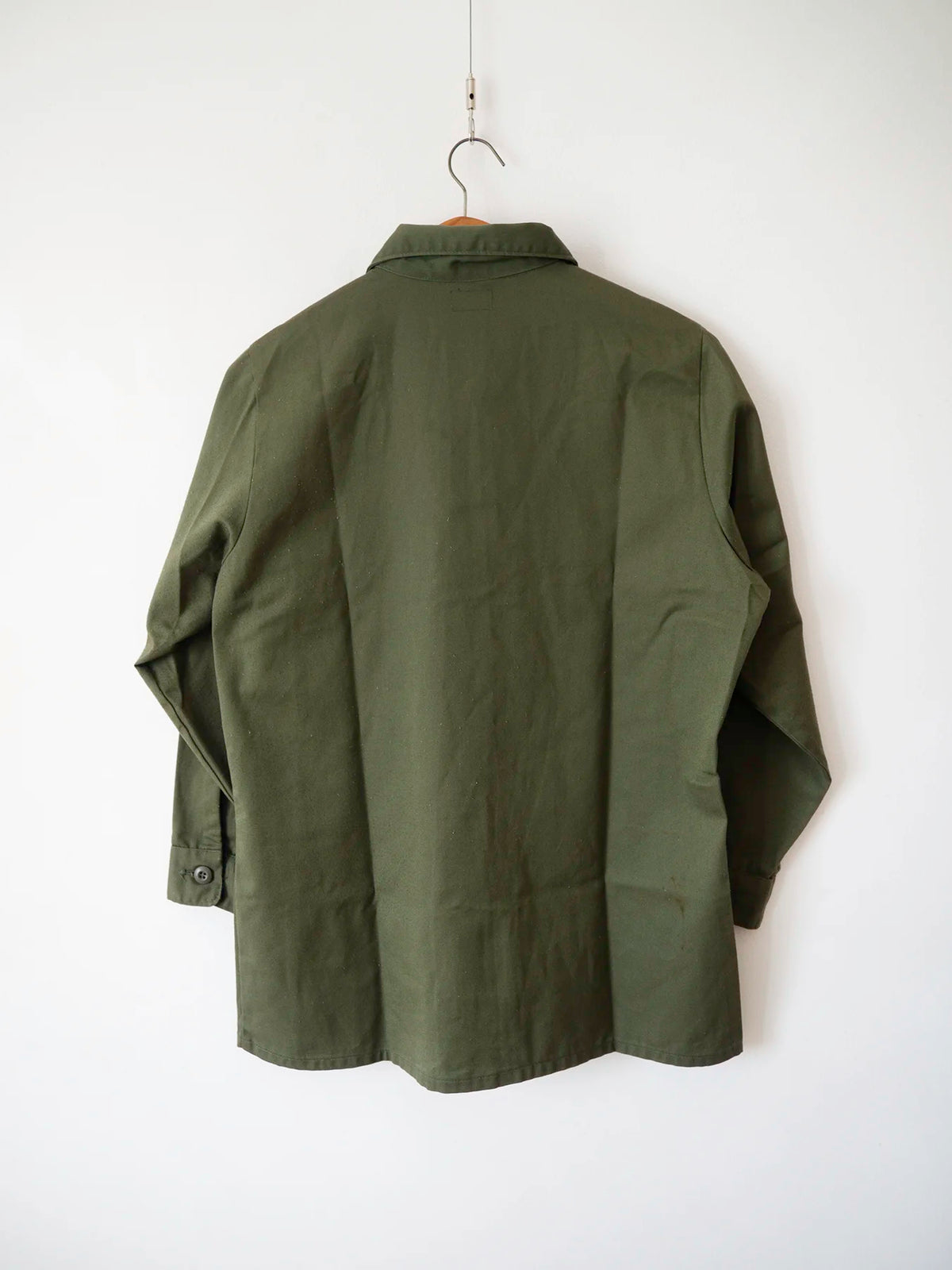 Back view of the OG-507 vintage US Army shirt in deep olive green durable press cotton-polyester.