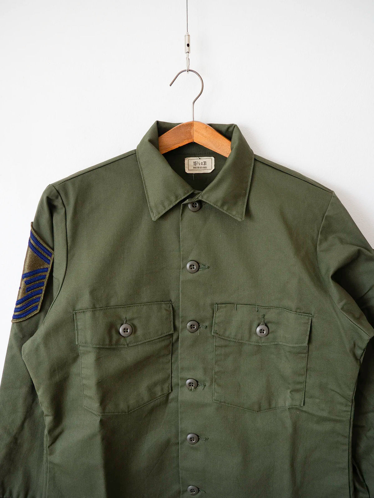 Close-up of the collar and chest pockets on the OG-507 vintage shirt with Air Force rank patch, size XL.