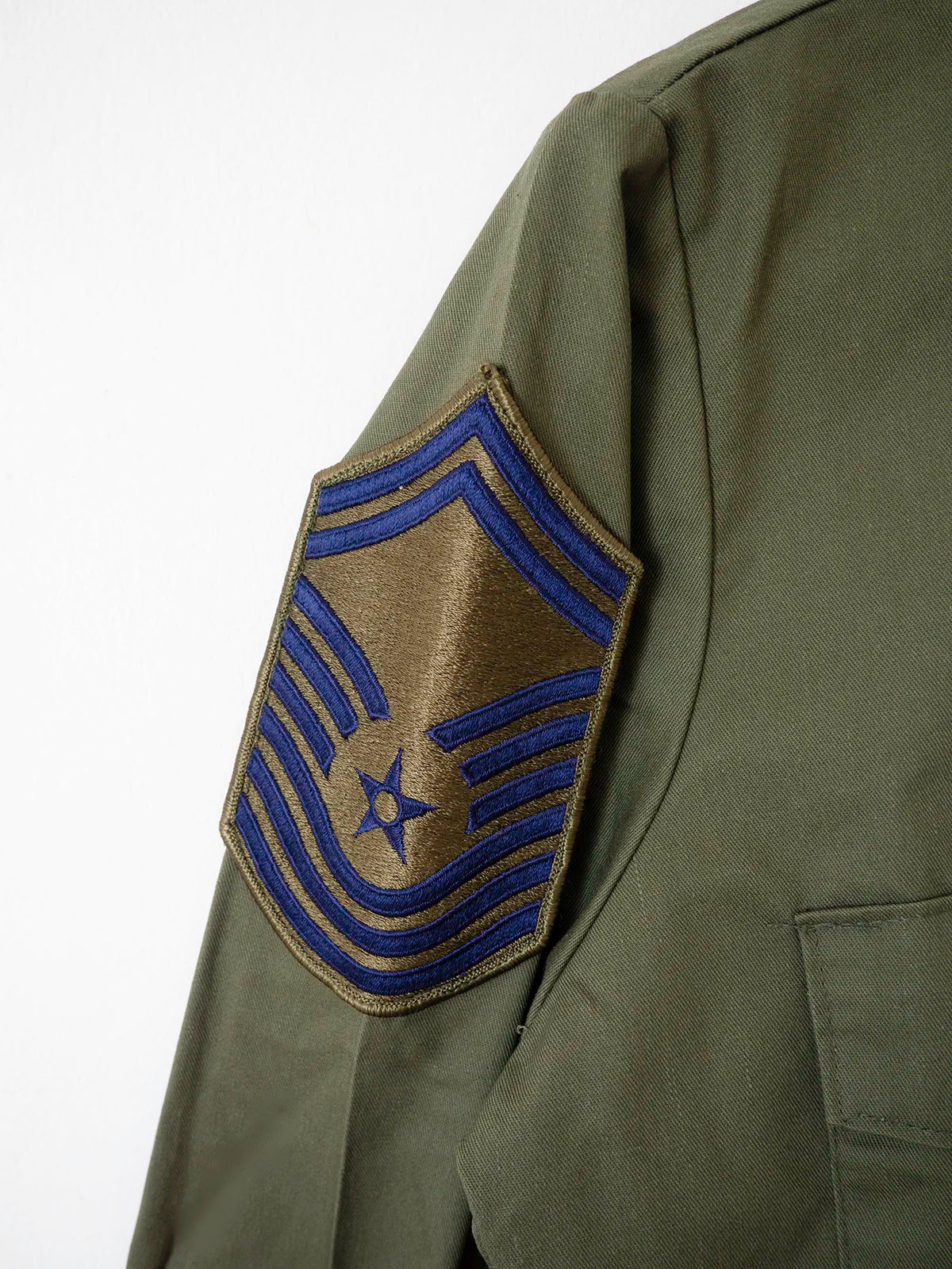 Detail of the Chief Master Sergeant rank chevron patch on the sleeve of the vintage OG-507 shirt.