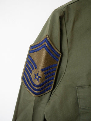 Detail of the Chief Master Sergeant rank chevron patch on the sleeve of the vintage OG-507 shirt.