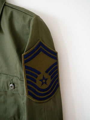 Close-up of the embroidered Chief Master Sergeant insignia on the OG-507 Air Force shirt.